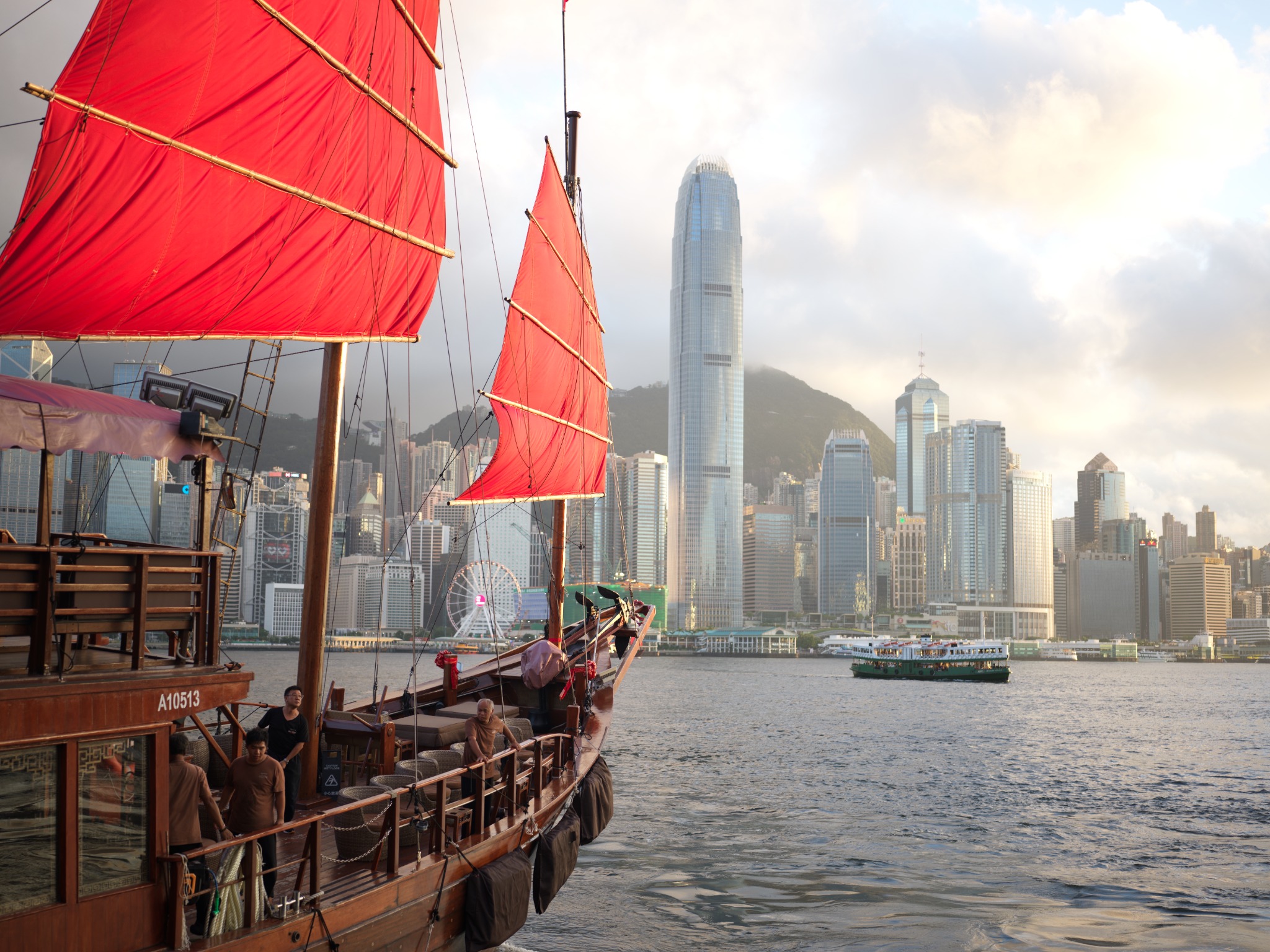Red sails crossing Hong Kong harbour in late afternoon light